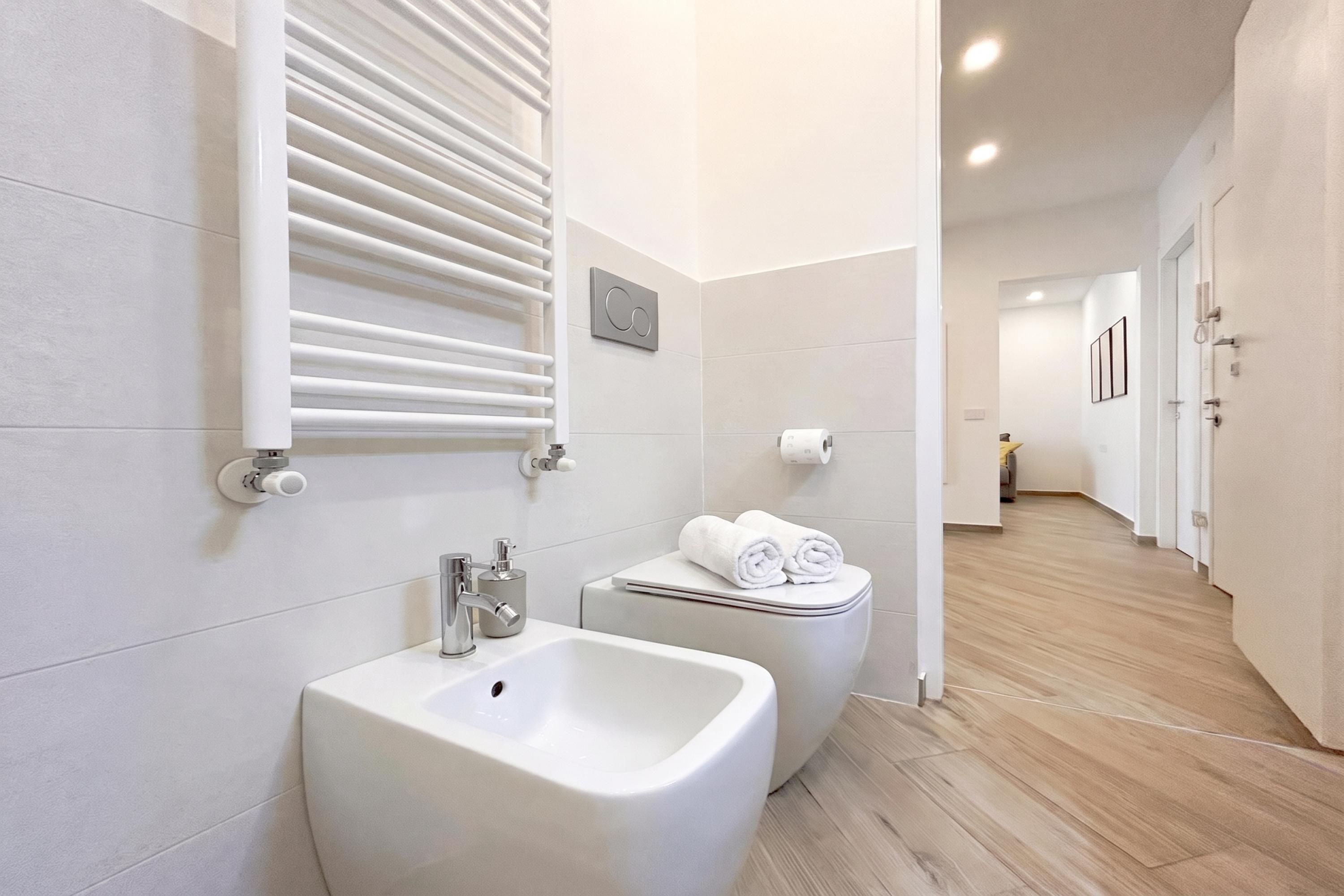 Un baño moderno con un bidé, un inodoro y un lavamanos.