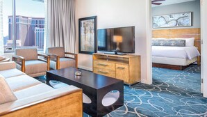 A hotel room with a sofa, chairs, a TV, a bed, and a view of the cityscape. - 2-bedroom suite in lovely Club Wyndham Desert Blue in Las Vegas During Formula 1 (Las Vegas)