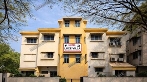 Un hotel de varios pisos con un cartel llamativo que dice "HOTEL LUXE VILLA".