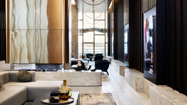 Eine moderne Lobby mit einem Marmor-Empfangstresen, einer Sitzecke und großen Fenstern.