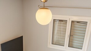 Una sala de estar moderna con un televisor de pantalla plana, un sofá gris, una mesa de centro de madera y un candelabro.