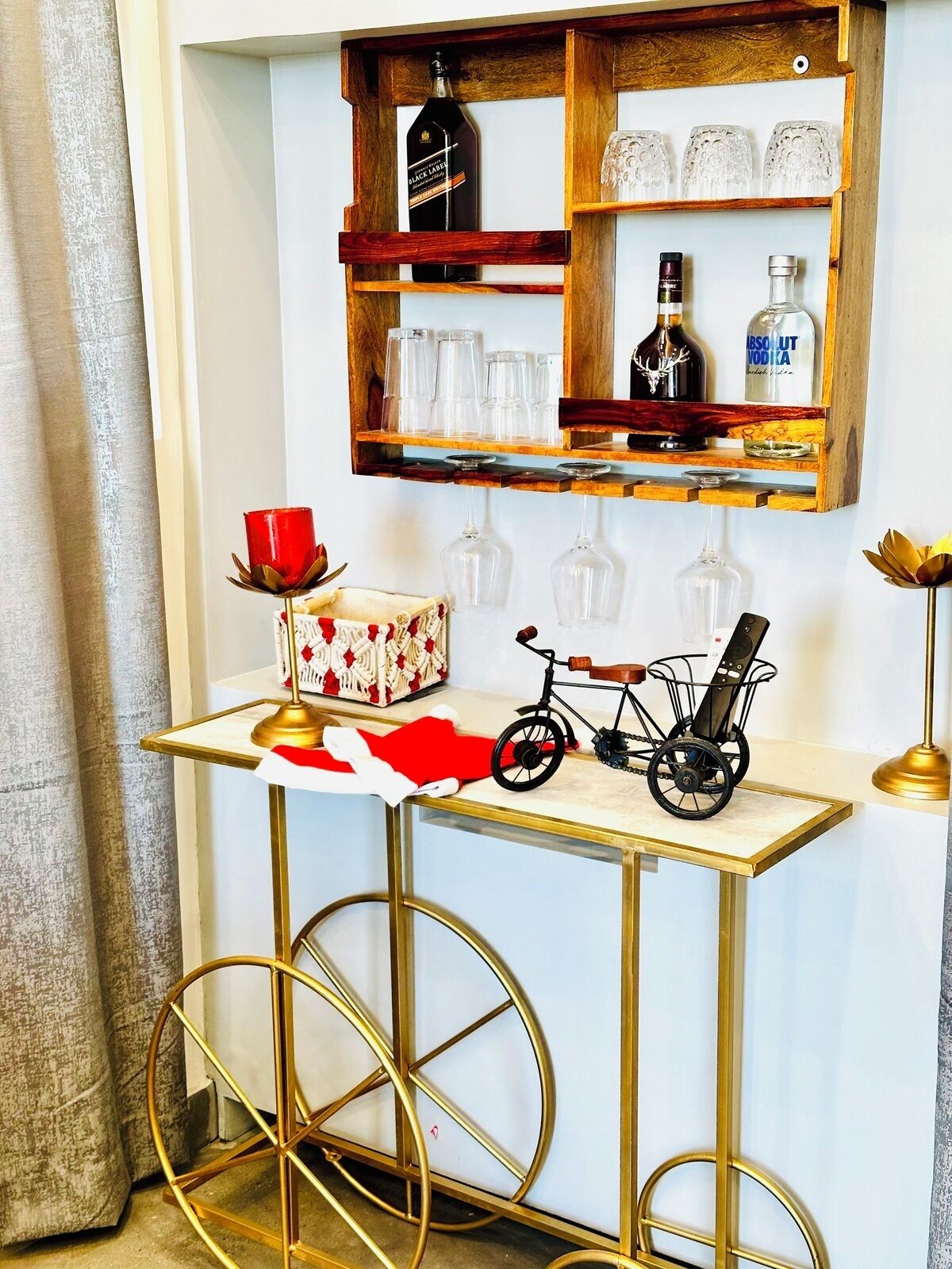 Una mesa pequeña con una bicicleta, un vaso rojo y una caja decorativa.