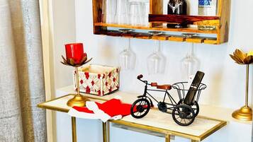 Una mesa pequeña con una bicicleta, un vaso rojo y una caja decorativa.