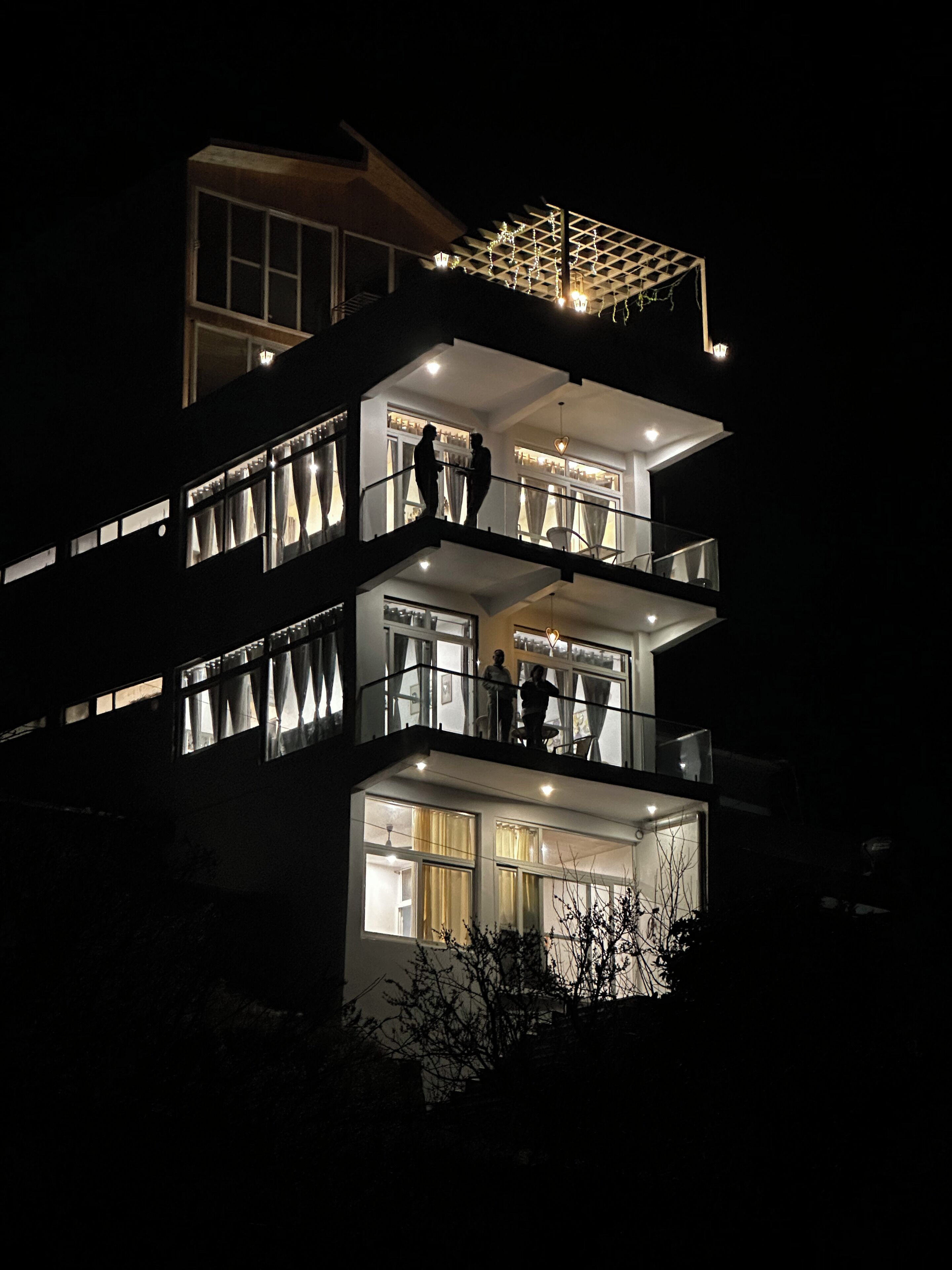 A multi-story building with balconies and large windows.