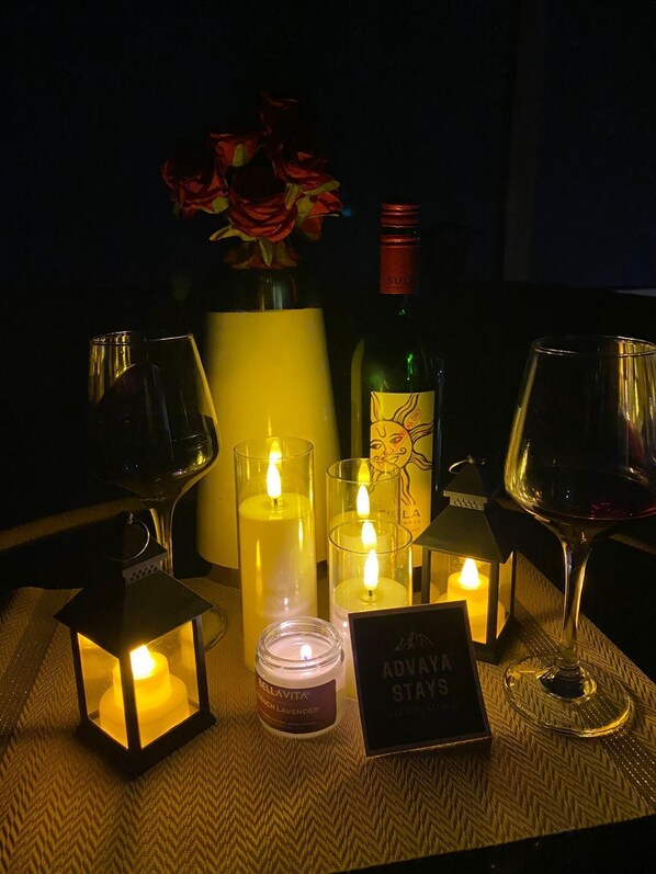 Una mesa con velas, vasos, una botella y un cartel que dice "ADVAVAS STAYS".