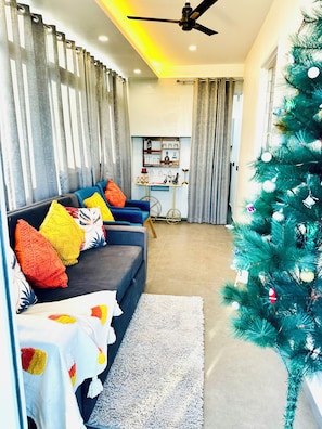 A modern living room with a sofa, a small table, and a Christmas tree.