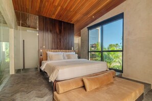 Un dormitorio moderno con una cama grande, techo de madera y un ventanal con vistas a zonas verdes.