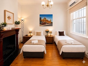A hotel room with two beds, a fireplace, a chandelier, and a large window. - Rare 3 Parking! Amazing City Views, CBD at Doorsteps, 3BR2B Beautiful Terrace (West Melbourne)