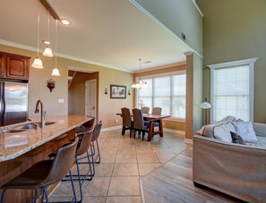 A spacious kitchen with a large island, bar stools, and a dining area with chairs and a table. - Spacious 3-Bedroom Townhome near Lake Hamilton (Hot Springs)