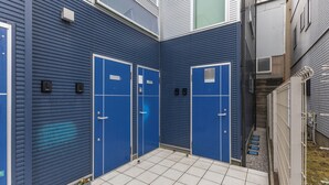 A blue exterior with two doors, a tiled floor, and a narrow pathway. - ANON Shibuya A103 (Tokyo)