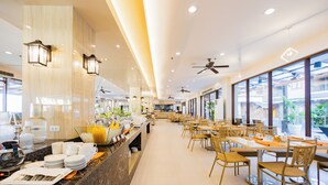 Un vaste espace de restauration dans l’hôtel, avec un long comptoir, de nombreuses tables et des chaises.