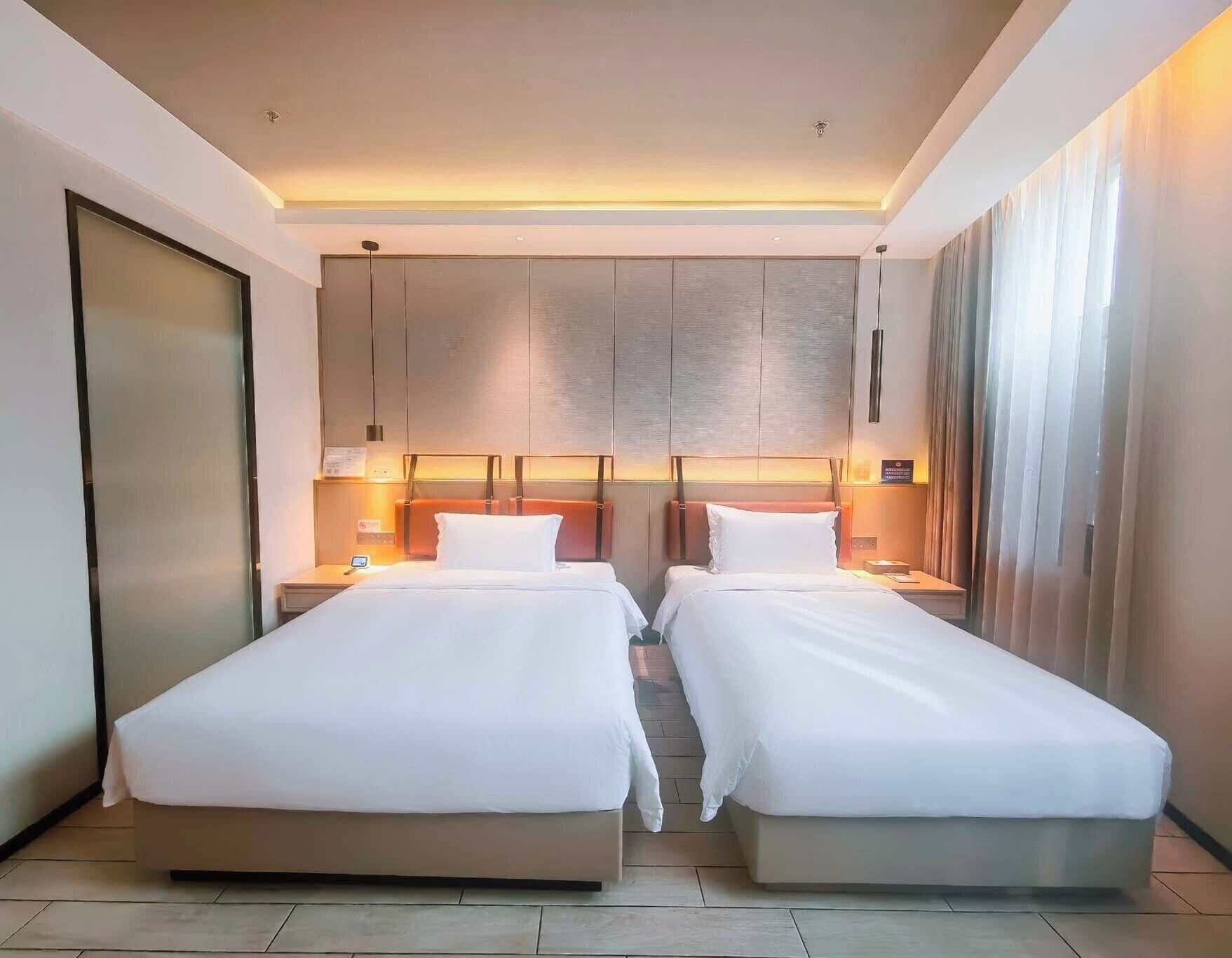 Habitación de hotel con dos camas, un armario grande y vistas a la ciudad.