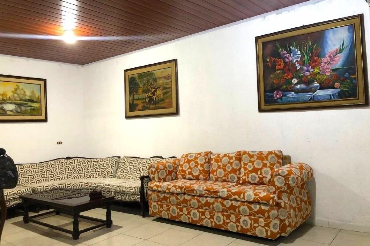 Une pièce comprenant un canapé, une table basse et trois tableaux accrochés au mur.