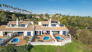 A large house with two swimming pools and a patio area.