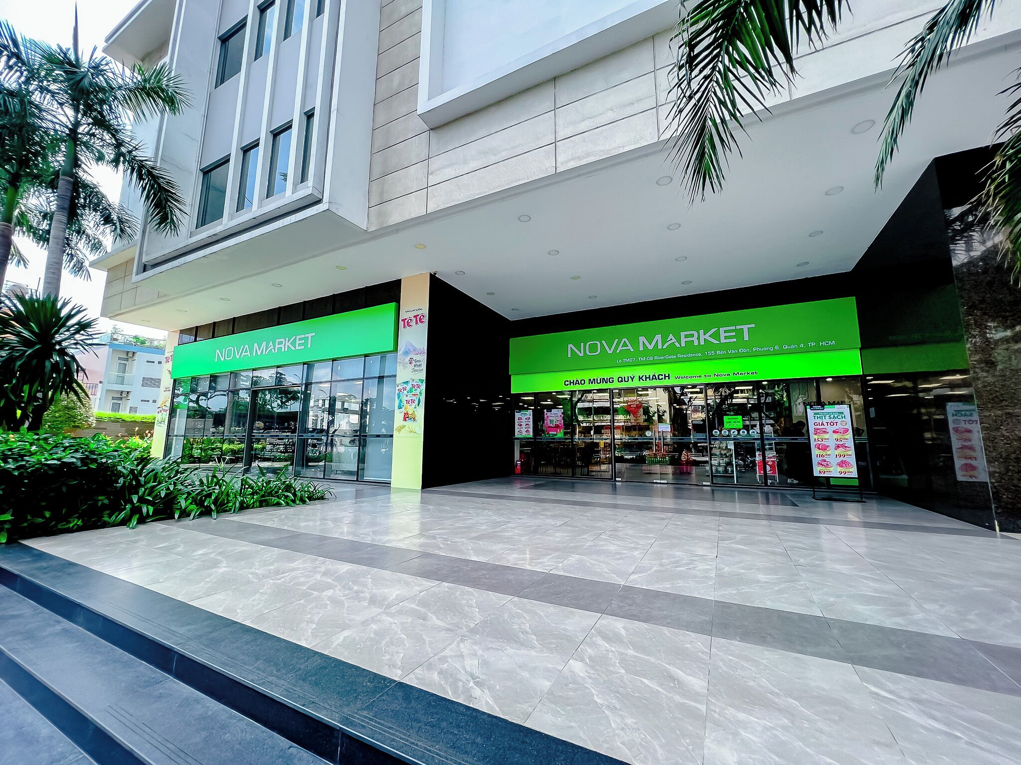 Un centro comercial moderno con dos tiendas 'Nova Market', con amplios ventanales de vidrio y un piso de baldosas limpias.