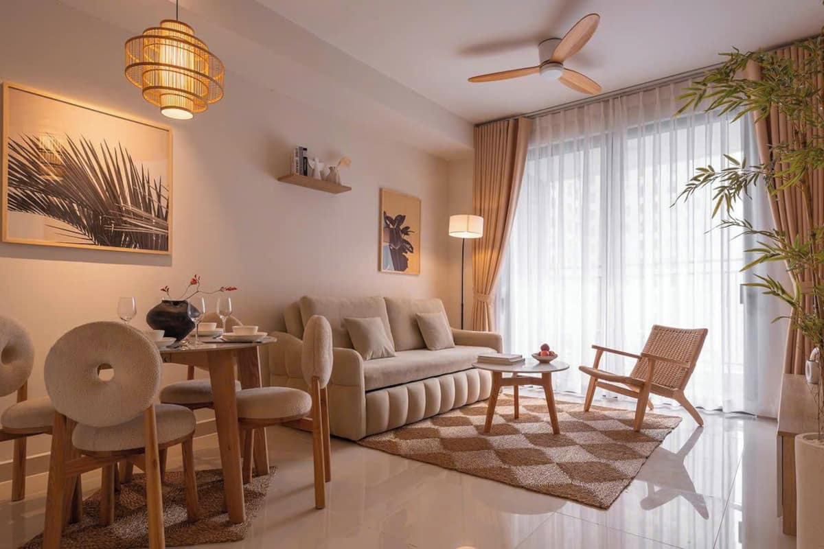 Een moderne woonkamer met een bank, stoelen, een salontafel en een eethoek. Er is een plafondventilator, een groot raam met gordijnen en een potplant.