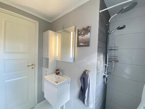 A bathroom with a white sink, a mirror, a towel rack, and a shower. - Cozy holiday home only 700 m from the water (Gilleleje)