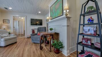 A living room with a fireplace, a map, a bookshelf, and a couch.