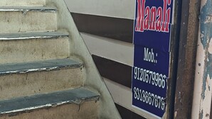 Una escalera que lleva al hotel 'OYO Hotel Manali', con los números de contacto 91205799966 y 8318667879.