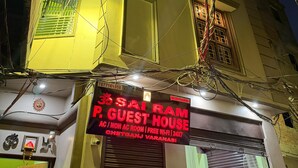A building with a sign advertising a guest house. The sign mentions free Wi-Fi and 24-hour service. - Om Sai Ram Paying Guest House (Varanasi)