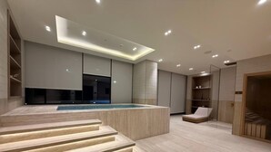 Een modern interieur met een zwembad, ingebouwde zitplaatsen en inbouwverlichting.