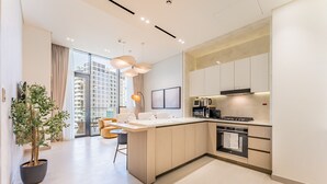 Een moderne keuken met een centraal eiland, ingebouwde apparatuur en een groot raam met uitzicht op de stad.