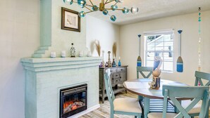 A dining area with a fireplace, teal chairs, and a chandelier. - < 1 Mi to Ramp! Boater's Retreat in Edgewater (Edgewater)