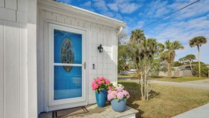 A house with a blue door, white siding, and a small porch with steps. There are two large flower pots on the porch. - < 1 Mi to Ramp! Boater's Retreat in Edgewater (Edgewater)