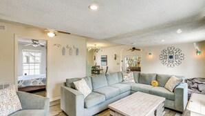 A living room with a sectional sofa, a wooden coffee table, and a ceiling fan. - < 1 Mi to Ramp! Boater's Retreat in Edgewater (Edgewater)