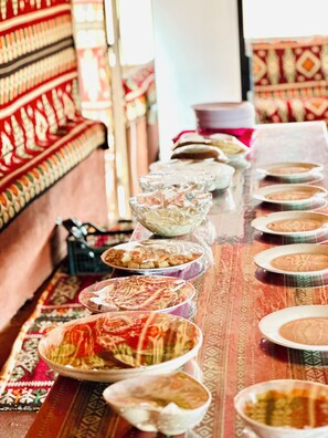 A long table with various dishes, possibly for a meal or event. - Desert Magic Camp &  (Wadi Rum)