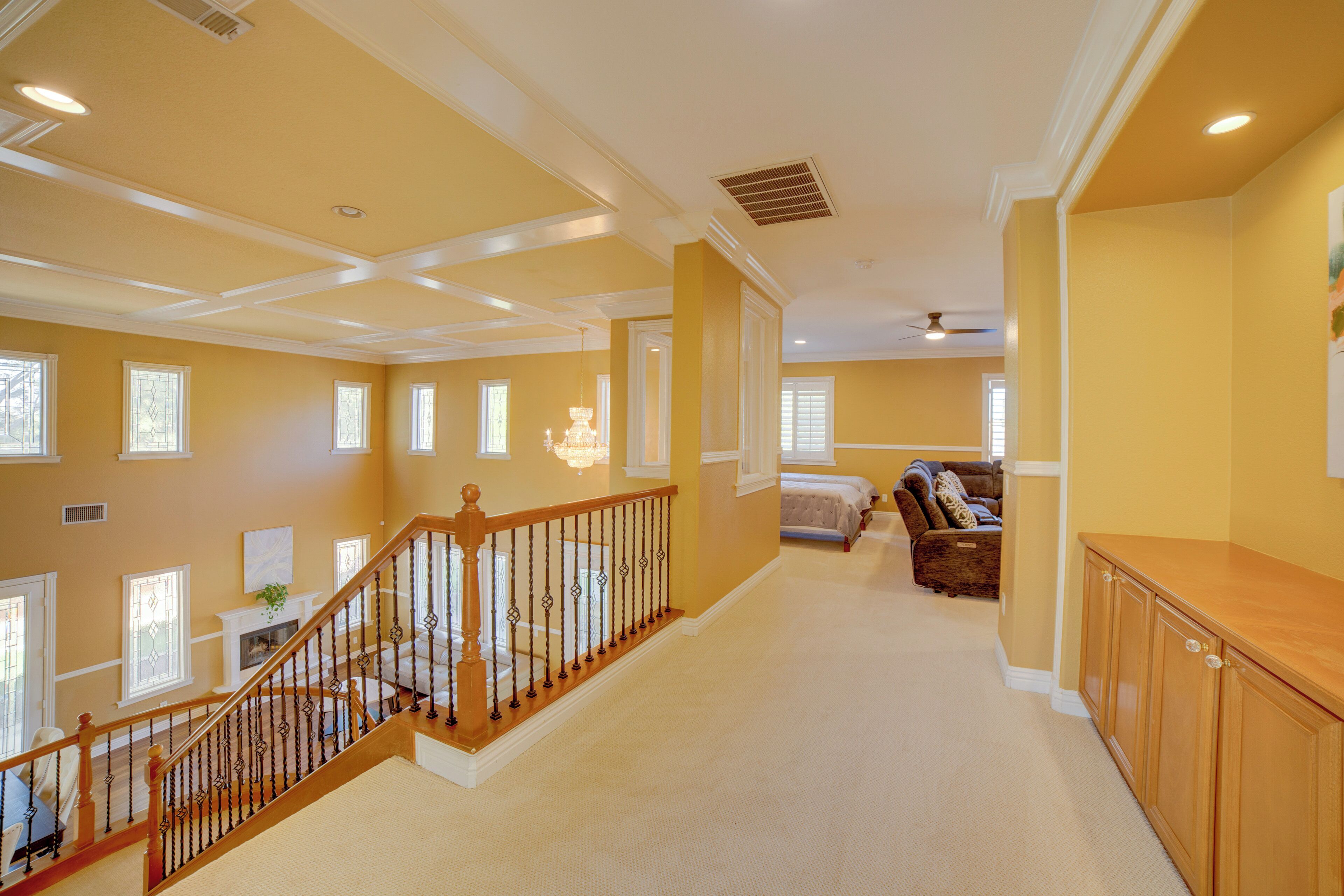 A spacious living area with a staircase, a fireplace, and a large window.