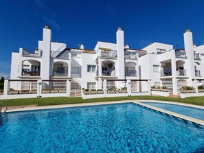 A modern white building with multiple balconies and a swimming pool in front. - Lovely flat with pool and terrace. HUTG-006152 (l'Escala)