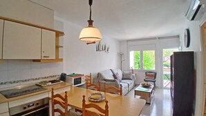 Een functionele keuken met een eethoek, een bank en een koelkast.