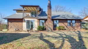 A two-story house with a brick exterior, a chimney, and a covered porch. - Groups Welcome, Central Location! Tulsa Gem + Yard (Tulsa)