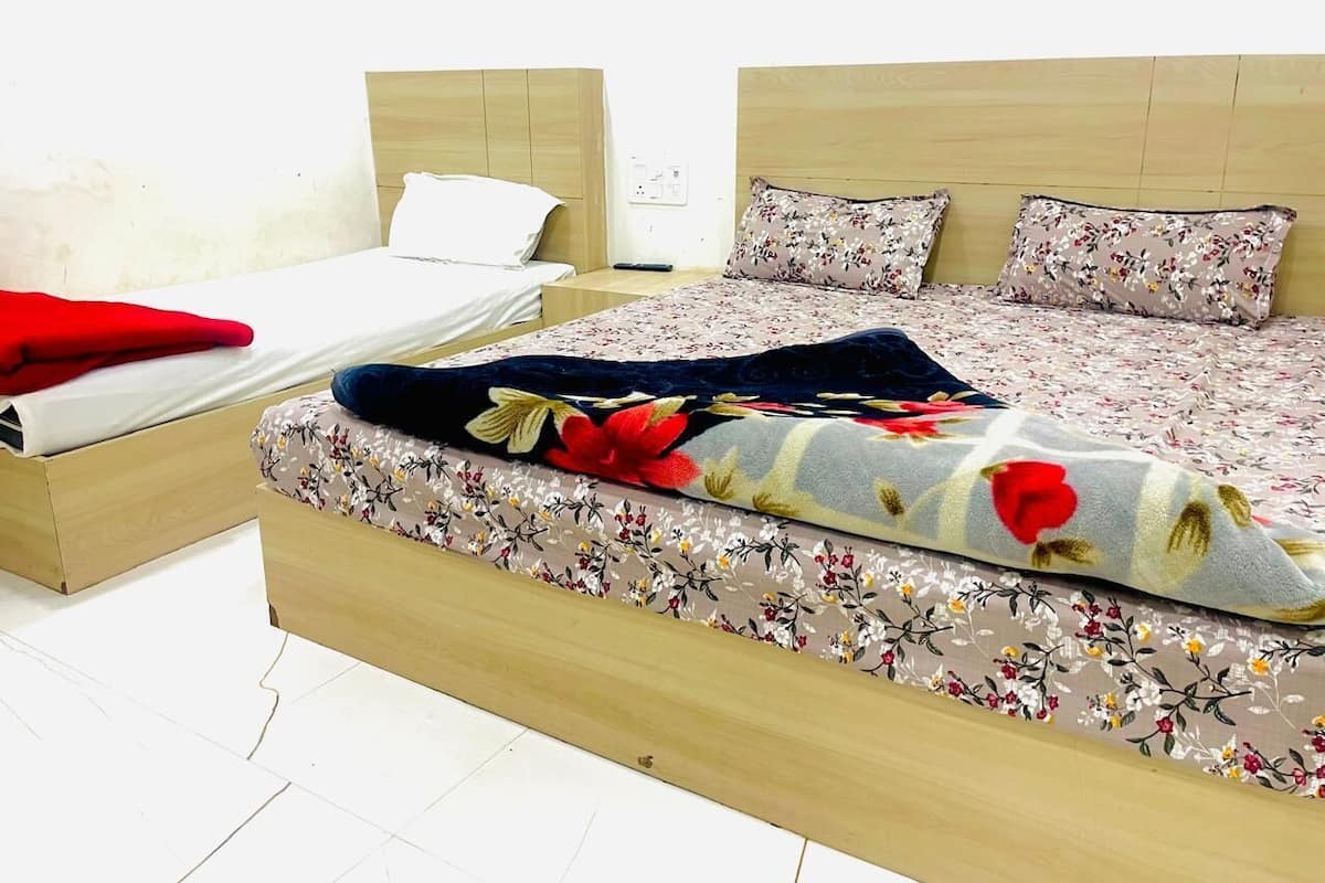 A double bed with a floral bedspread and two pillows.