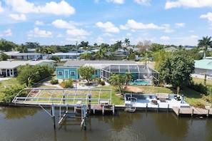 A waterfront property with a dock, a pool, and a house with a blue exterior. - Heated Pool & Boat Dock! Port Charlotte Getaway (Port Charlotte)