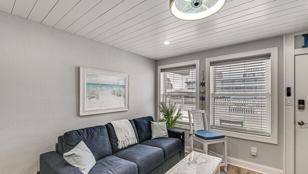 A modern living room with a grey sofa, a coffee table, and a painting on the wall. - Walk to Beach & Boardwalk! Wildwood Crest Getaway (Wildwood Crest)