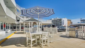 A covered outdoor seating area with a gazebo, white chairs, and a grill. - Walk to Beach & Boardwalk! Wildwood Crest Getaway (Wildwood Crest)