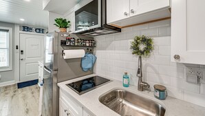 A modern kitchen with white cabinets, a stainless steel sink, a built-in oven, and a backsplash. - Walk to Beach & Boardwalk! Wildwood Crest Getaway (Wildwood Crest)