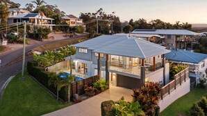 Et moderne hus i to etager med stor balkon, swimmingpool og velholdt have.