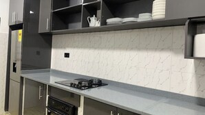A kitchen with a marble backsplash, stainless steel appliances, and a countertop with a gas stove. - Tree fort property 2 in North Legon (Accra)