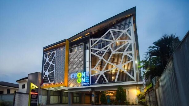 Um edifício moderno com padrões geométricos e uma placa com a inscrição "FRONTONE".