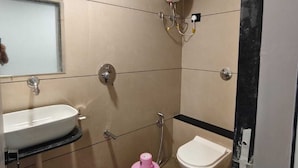 Un bagno piccolo con lavandino, water e doccia.