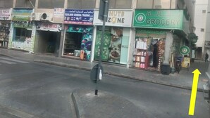 A street view with various storefronts including a hardware store, a typing service, a grocery store, and a nut zone. - OST Diera Market Homes (Dubai)