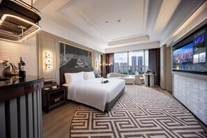A modern hotel room with a large bed, a desk, and a city view. - Elegant Hotel Guagnzhou Ersha Island (Guangzhou)