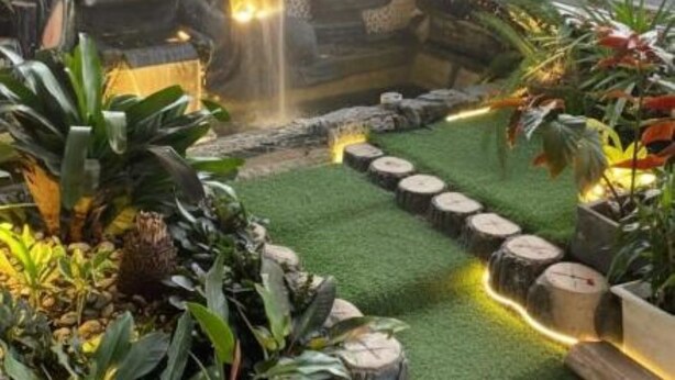 A landscaped garden with a waterfall, artificial grass, and various plants. - Shaionara Villa (Parongpong)