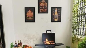 A small outdoor area with a grill, a table with food, and two yellow bean bags. - Shaionara Villa (Parongpong)