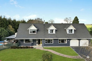 A two-story house with a dark grey roof, white trim, and a garage.