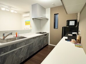 A modern kitchen with a stainless steel sink, a built-in oven, and a coffee machine. - Yubikan - Newly built 120 sq.m. (with double terrace and parking space) (大阪市)