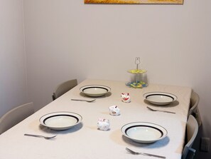 A dining table set with plates, cutlery, and a decorative item. - Yubikan - Newly built 120 sq.m. (with double terrace and parking space) (大阪市)